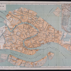 May include: A vintage map of Venice, Italy, with a detailed illustration of the canals and islands. The map is printed on a light blue background with brown and orange lines and text. The title "VENEZIA" is printed in the top left corner.