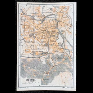 Può includere: Un'antica mappa stampata di Vicenza, Italia, dotata di un sistema a griglia con lettere A-D e numeri 1-6. La mappa mostra strade, edifici e l'area di Campo Marzio in inchiostro arancione e nero su sfondo bianco con scala 1:17.600.