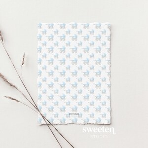 Sweeten Studio's template which includes a soft pastel blue watercolor background with a subtle fabric texture and a delicate blue ribbon-style border, sized for a 5x7 baby shower invitation.