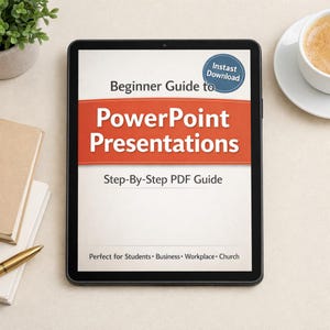 May include: A black tablet displays a "Beginner Guide to PowerPoint Presentations" PDF. The title is in large, bold, orange letters. The tablet is on a light-colored surface, with a cup of coffee and a notebook nearby.