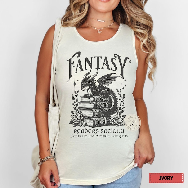 May include: Ivory sleeveless tank top with a black and white illustration of a dragon sitting on a stack of books. The text "Fantasy Readers Society" is printed below the illustration, along with the words "Castles, Dragons, Wizards, Heroic Quests".