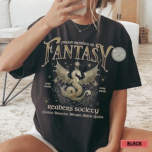 May include: Black t-shirt with a gold graphic of a dragon and the text "Proud member of Fantasy Readers Society Castles, Dragons, Wizards, Heroic Quests".