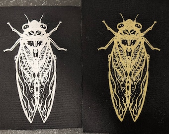 Parche de tela con forma de cigarra