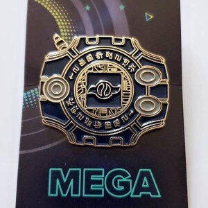 May include: A gold and blue Digimon pin featuring the Digivice with the text "MEGA BITEZ" on the card.