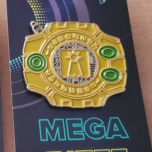 May include: A gold-colored pin with a circular design featuring a black and white symbol with a sun and a tower. The pin has two green circles on the side and the text "MEGA BITEZ" in green and yellow on a black background.