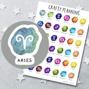 Könnte beinhalten: Ein runder Aufkleber mit einem weißen Widder-Sternzeichen auf blau-grünem Aquarellhintergrund und dem Text Aries, neben einem rechteckigen Bogen mit der Aufschrift Crafty Planning, der verschiedene bunte Sternzeichen-Aufkleber zeigt.