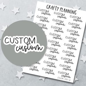 Puede incluir: Una hoja de pegatinas blanca titulada Crafty Planning con varias filas de pegatinas de texto negro que dicen custom en dos fuentes diferentes. Una pegatina circular grande con el mismo texto se superpone a la hoja.
