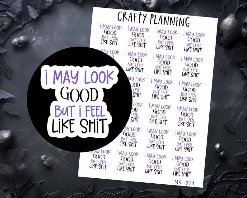 Puede incluir: Una pegatina negra con el texto "I MAY LOOK GOOD BUT I FEEL LIKE SHIT" en letras blancas y moradas. Tambi&eacute;n se ve una hoja de pegatinas con el mismo texto. Las pegatinas son para planificar y hacer manualidades.