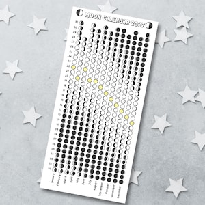 May include: A vertical 2027 moon calendar printed on white paper, featuring black and white circular icons representing lunar phases for each day of the year. The months are listed at the bottom, and specific dates are highlighted with yellow circles.