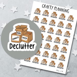 May include: A sheet of Crafty Planning stickers featuring brown cardboard boxes labeled Bin, Donate, and Keep. Each sticker includes the text Declutter. A circular overlay shows a larger version of the box illustration with the word Declutter below.