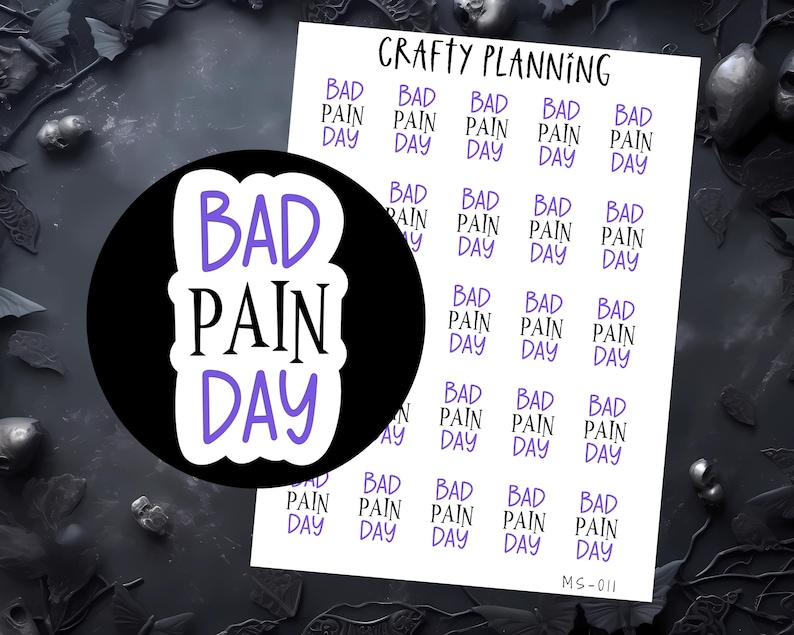 K&ouml;nnte beinhalten: Ein Bogen mit Planer-Aufklebern mit dem Text "BAD PAIN DAY" in Schwarz und Lila. Die Aufkleber sind in einem Raster angeordnet, wobei der Satz wiederholt wird. Der Text "Crafty Planning" ist oben aufgedruckt.