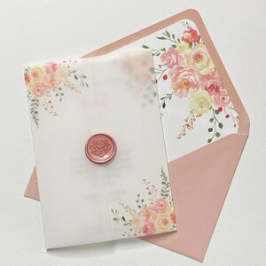 May include: A blush pink envelope with a floral design and a wax seal. The envelope is made of translucent paper and has a white floral design on the front. The wax seal is a deep red colour and has a floral design.