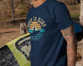 Camiseta "Born To Surf", camiseta de surf, camiseta de surfista, camiseta de playa, camiseta de estilo oceánico, camiseta con gráfico costero, camiseta de surf al atardecer