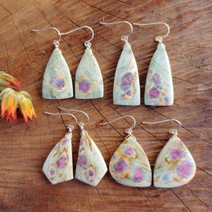 Peut inclure: Six paires de boucles d'oreilles pendantes avec des pierres précieuses vertes, roses et dorées. Les boucles d'oreilles sont faites avec des crochets en argent.