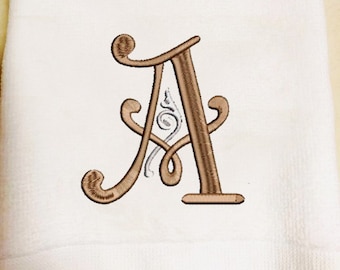 May include: White hand towel with a brown embroidered letter A with a decorative swirl design.