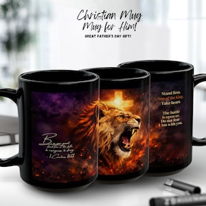 May include: Three black ceramic mugs featuring a graphic of a roaring lion against a fiery background with a glowing cross. The mugs display the text: Be on your guard, stand firm in the faith; be courageous; be strong. - 1 Corinthians 16:13.