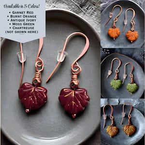 May include: A pair of garnet red leaf-shaped earrings with copper-toned wire hooks and clear plastic backings. The text in the image reads: Available in 5 Colors! Garnet Red, Burnt Orange, Antique Ivory, Moss Green, Chartreuse (Not Shown Here).