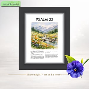 Op de afbeelding: Ingelijste kunstdruk met Psalm 23, met een aquarel landschap van een beek, bergen en wilde bloemen. De tekst "A Psalm of David" staat eronder. De lijst is zwart, met een paarse bloem in de hoek.