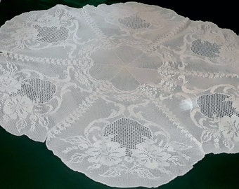 A round hand made crochet tablecloth .