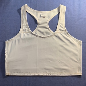 May include: A white racerback crop top featuring a scoop neckline and visible light-colored stitching along the seams. The garment includes a small interior label at the neckline with the text Amylu's Design, One Category, 100% Made in France.