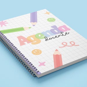 Puede incluir: Un cuaderno de espiral con las palabras "Agenda docente" en colores pastel. El cuaderno presenta un patrón de cuadrícula e ilustraciones coloridas de lápices, estrellas y caras sonrientes sobre un fondo azul claro.
