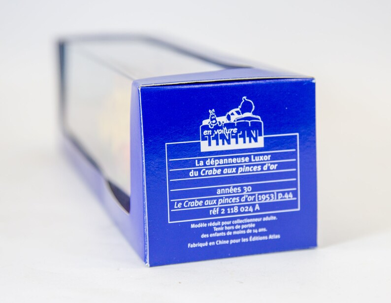 Puede incluir: Caja azul con una ventana de pl&aacute;stico transparente que muestra un coche de juguete rojo, blanco y amarillo. La caja tiene texto en franc&eacute;s que dice "en voiture Tintin" y "La d&eacute;panneuse Luxor du Crabe aux pinces d'or ann&eacute;es 30 Le Crabe aux pinces d'or [1953] p.44 r&eacute;f 2 118 024 A Mod&egrave;le r&eacute;duit pour collectionneur adulte. Tenir hors de port&eacute;e des enfants de moins de 14 ans. Fabriqu&eacute; en Chine pour les Editions Atlas".