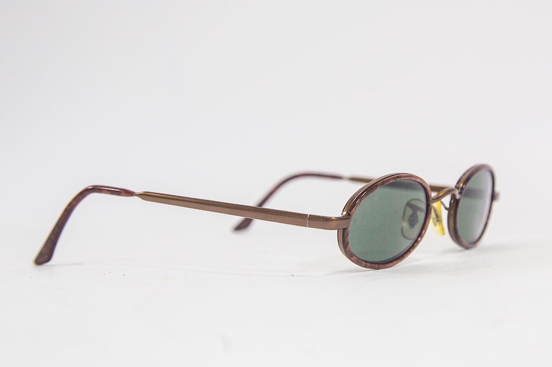 May include: Brown metal framed oval sunglasses with green lenses.