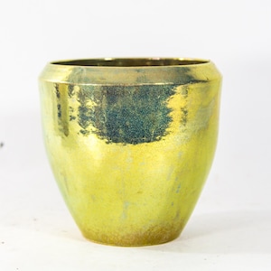 Könnte beinhalten: Ein großer, grüner Keramiktopf mit glänzender, irisierender Glasur. Der Topf hat eine abgerundete, leicht ausgestellte Form.