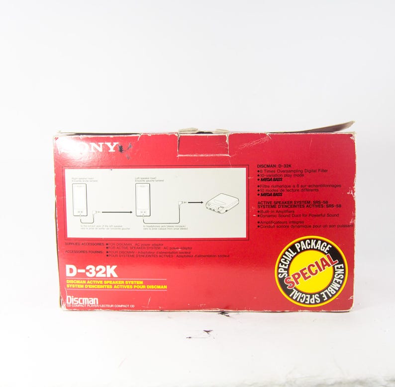 May include: A red and white box for a Sony Discman D-32K active speaker system. The box features a diagram of the system with two speakers and a connection cable. The text on the box reads "Discman Active Speaker System" and "Special Package Ensemble Special".