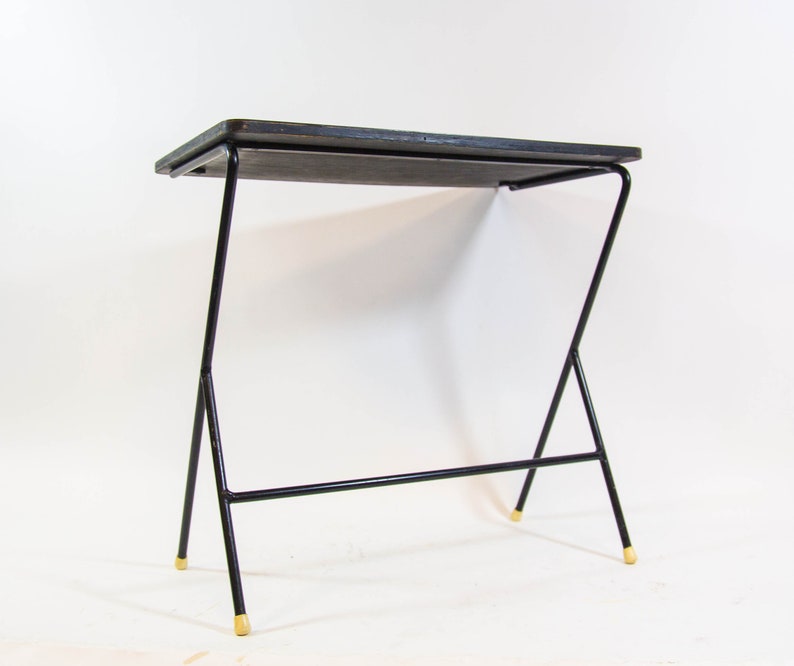May include: A black metal side table with a rectangular wooden top and gold-coloured tips on the legs.