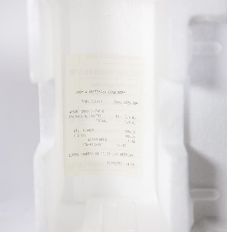 May include: A white receipt with black text from UROOM & DREESMANN GRONINGEN. The receipt shows a purchase of a portable audio/tel device for &pound;299.00, with a total of &pound;399.00. The receipt also shows a breakdown of the cost, including &pound;300.00 for the device, &pound;100.00 for cash, and &pound;1.00 for change. The receipt is dated 10/05/3 14:45.