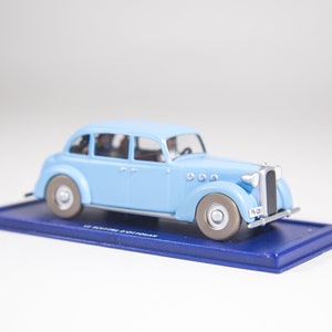 May include: A light blue toy car model with a silver number plate that reads "PV-2381". The car is on a blue display base.