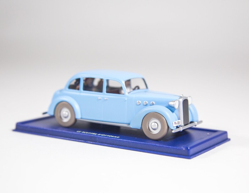 May include: A light blue toy car model with a silver number plate that reads "PV-2381". The car is on a blue display base.