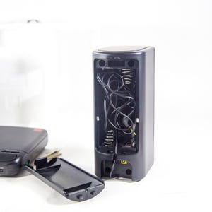 May include: A black and grey portable CD player with the top and bottom compartments open, revealing the internal wiring and components.