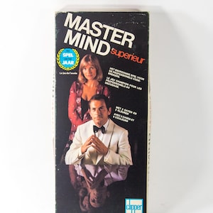 May include: A game box for the Mastermind board game. The box features a black background with the game's name in white and red text. The box also features a photo of two people, a woman in a red dress and a man in a white tuxedo. The text on the box reads "Mastermind superieur" and "Het bekroonde spel voor de professionele code-brekers."