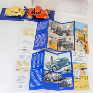 Puede incluir: Un folleto de varios paneles con ilustraciones de coches antiguos y personajes de dibujos animados. El folleto presenta una combinaci&oacute;n de colores rojo, blanco y azul e incluye texto en holand&eacute;s. El texto dice "De Stroomlijn Wereld" y "H&eacute;? ... Wat nu? ... Waarom rij ik nu achteruit? ..."