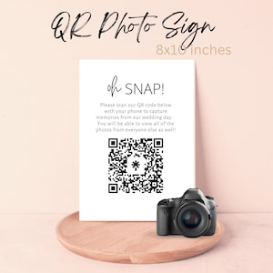 Puede incluir: Un cartel blanco de 20,3 x 25,4 cm con texto negro que dice "QR Photo Sign" y "oh SNAP!"  El cartel indica a los invitados que escaneen el código QR que aparece a continuación con su teléfono para capturar recuerdos del día de la boda. Un código QR en blanco y negro se muestra en el cartel, junto con una cámara negra.