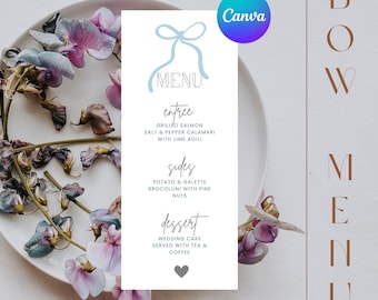 May include: A white menu card with a blue ribbon design. The menu includes entree, sides, and dessert options. The text reads: "MENU", "entree", "GRILLED SALMON", "SALT & PEPPER CALAMARI", "WITH LIME AOILI", "sides", "POTATO & GALETTE", "BROCOLLINI WITH PINE NUTS", "dessert", "WEDDING CAKE", "SERVED WITH TEA & COFFEE".