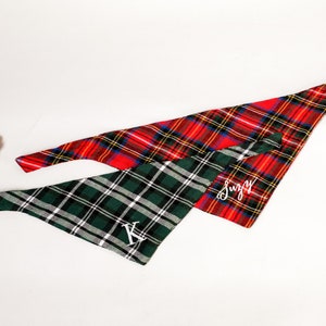 Pu&ograve; includere: Due bandane per cani a quadri, una rossa e nera e una verde e nera. La bandana rossa ha il nome "Suzy" ricamato, e la bandana verde ha la lettera "K" ricamata.