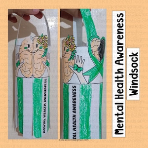 May include: A green and white paper craft windsock with a brain and a green ribbon. The windsock has the text "Mental Health Awareness" printed on it.