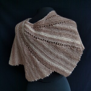 May include: A brown and white striped knitted shawl with a scalloped edge.