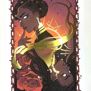 Puede incluir: Una impresión artística que presenta una ilustración estilizada de una mujer con piel oscura y cabello trenzado. La obra de arte incluye detalles dorados, rosas y un borde decorativo con un diseño de cadena y espinas. La paleta de colores incluye tonos de rojo, dorado y negro.