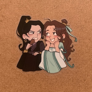 May include: Two cartoon characters, one with dark hair and a black outfit, the other with brown hair and a light blue dress, are depicted in a close-up illustration. The character with dark hair is holding a brown object in their hand.
