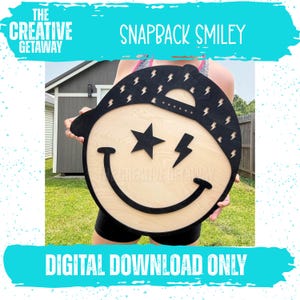 May include: A wooden snapback smiley face with a black cap, star eyes, and lightning bolt accents. The smiley face has a natural wood grain finish. The text "THE CREATIVE GETAWAY" and "SNAPBACK SMILEY" are displayed at the top, with "DIGITAL DOWNLOAD ONLY" at the bottom.
