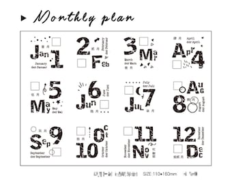 May include: A white monthly planner with black text and numbers. The planner includes the months of the year, with each month's name and number displayed in a unique font. The text "Monthly plan" is at the top.