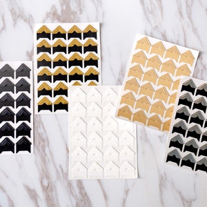 May include: Five sheets of corner stickers for scrapbooking or photo albums. The sheets are white with black, gold, gray, and white corner stickers.