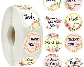 Può includere: Rotolo di adesivi rotondi con disegni floreali e il testo "Grazie" in vari stili. Gli adesivi sono su sfondo bianco con accenti rosa e gialli.