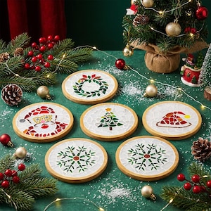 May include: A set of six round Christmas coasters with mosaic designs. The coasters feature images of a wreath, Santa Claus, a Christmas tree, a Santa hat, and snowflakes. Each coaster has a light wood border.