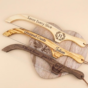 Könnte beinhalten: Drei Käsehobel aus Holz mit Drahtschneider, jeweils mit einzigartiger Holzmaserung und individueller Lasergravur. Der oberste Hobel trägt die Aufschrift Savor Every Slice mit H-Monogramm, der mittlere Gourmet Crusts mit Julian und der unterste A Slice of Heaven - John 6:51 mit einer Brotkorb-Grafik.