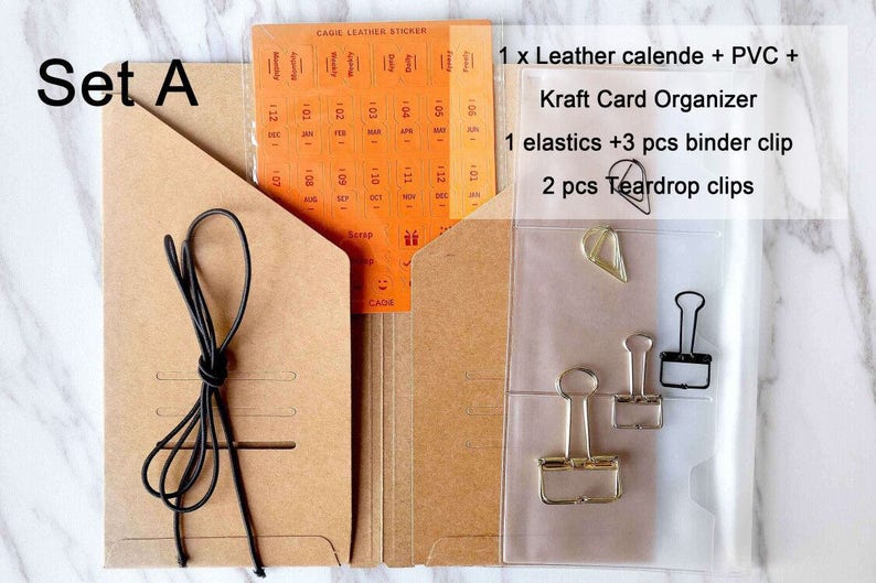 May include: Set A of brown kraft paper folders with a clear plastic pocket. The pocket contains a black binder clip, two gold binder clips, and a gold teardrop clip. The folder also includes a black elastic band and a sheet of orange calendar stickers.